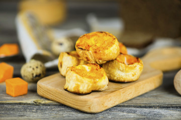 Baked roll with pumpkin and cheese stuffing on a wooden board