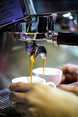 Fototapeta na wymiar espresso shot from coffee machine in coffee shop,Coffee maker in coffee shop