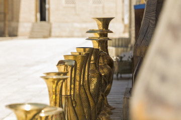 antique oriental uzbek jugs made of bronze on blurred background