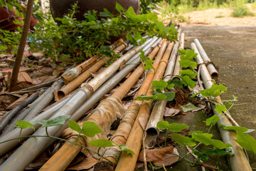 Vintage Old PVC Pipes with Water Hose - Outdoor Garden/ Green Leaves/ Moldy Concrete Texture/ Perspective