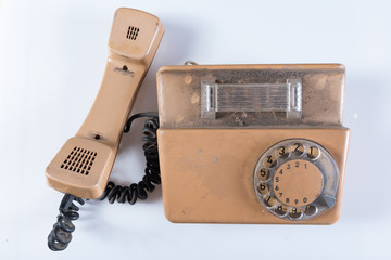 Stary telefon ze słuchawką i tarczą analogową.