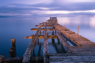 Old broken down wooden pier in Punta Arenas, old dock in Chile on the Pacific ocean