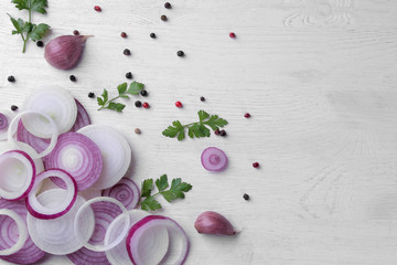 Rings cut into red onions with herbs and spices on a white wooden table. vegetables. top view - Powered by Adobe