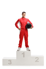 Male racer winner on a winner's pedestal holding a helmet