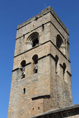 Fototapeta na wymiar The stone bell tower of the romaneque Holy Mary Church (Iglesia de Santa Maria) in Ainsa, a small rural village in the Spanish Aragonese Pyrenees mountains
