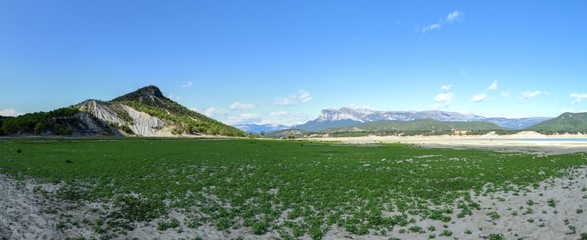 A green landscape of the Mediano artificial lake in the Spanish Aragonese Pyrenees as seen from...