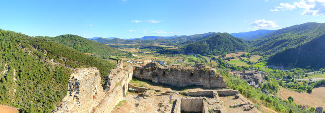 A landscape of cultivated fields, dense forest and mountains as seen from the ruins of the abandoned castle in the rural medieval town of Boltaña, in the Spanish Aragonese Pyrenees