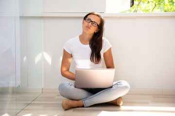 Thoughtful Young Woman Using Laptop