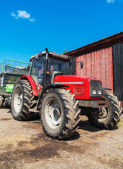 Fototapeta na wymiar Tractor with a trailer for hay on the farm.