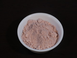 Black Salt Powder, black ground salt from the Himalayas heap pile close up isolated ,Indian Black salt, Kala namak,,Kala namak or Black salt,Black salt in white bowl on wooden background,