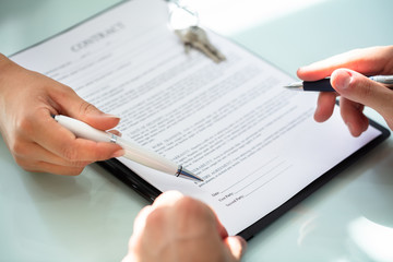 Close-up Of A Person's Hand Filling Contract Form