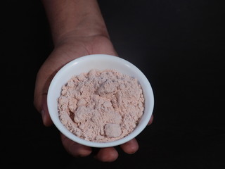 Black Salt Powder, black ground salt from the Himalayas heap pile close up isolated ,Indian Black salt, Kala namak,,Kala namak or Black salt,Black salt in white bowl on wooden background,