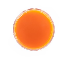 Closeup top view glass of fresh carrot juice isolated on white background, healthy diet food drink