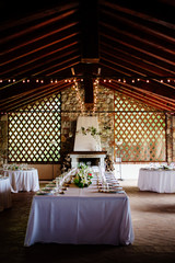 hall with table set for wedding party lit candles