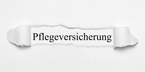 Obraz premium Pflegeversicherung auf weißen gerissenen Papier