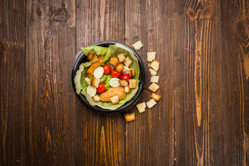Caesar salad with chicken, cherry tomatoes and quail eggs on a plate