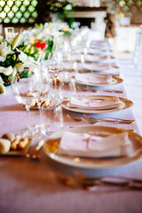 hall with table set for wedding party lit candles