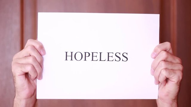 Holding "Hopeless" inscription overhead