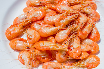 boiled red shrimps on wooden tray, seafood background
