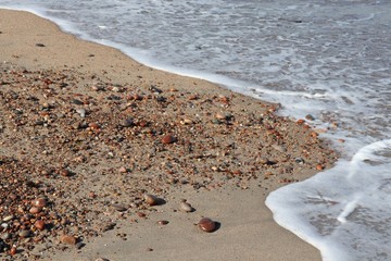 Tide arriving on beach with pebbles
