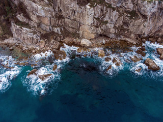 Obraz premium Airial view of the waves crashing on the rocks