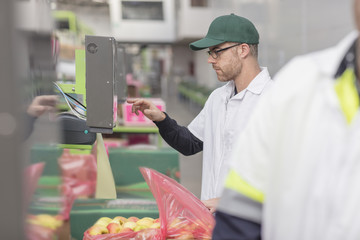 Worker typing in code into machine