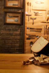 close-up shot of sliced cheese with knife on wooden cutting board