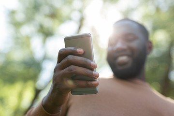 Technological progress. Selective focus of a modern innovative smartphone being in hands of a cheerful young man