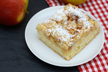apple cake and apple standing on black slate