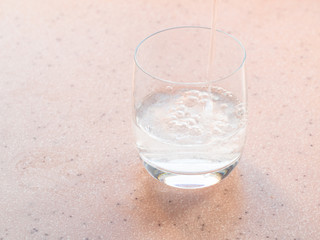 trickle of carbonated water pours in glass