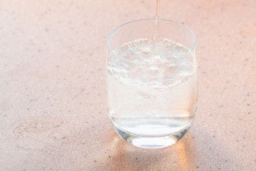 natural carbonated water pours in glass