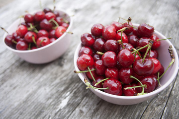 Bowl of cherries on a worn wooden background