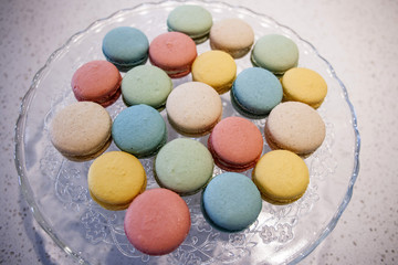 Fototapeta na wymiar Colorful Almond Cookie Macarons or Macaroons on Glass Platter.