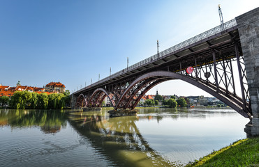 Fototapeta na wymiar Drava river, sky reflection and bridge. The Main Bridge across Drava river in Maribor, Slovenia