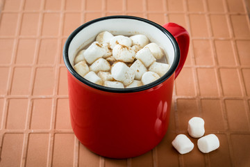Christmas cocoa with marshmallow in mug on brown background
