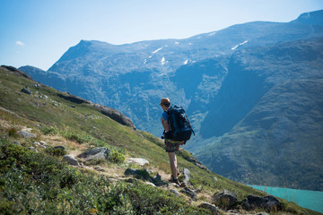 Fototapeta na wymiar male hiker with backpack walking on Besseggen ridge over Gjende lake in Jotunheimen National Park, Norway