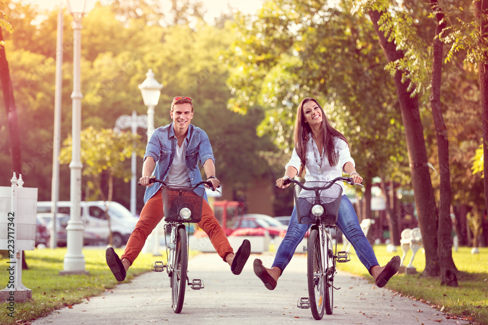 Wall mural happy autumn funny couple riding on bicycle