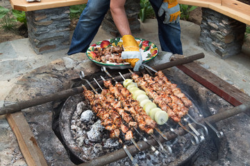 Barbeque meat kebabs.Grilled kebabs cooking on metal skewers.Outdoor kitchen. Picnic.
