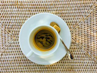 one cup of espresso with sugar and a spoon located on a underlay - topview