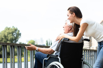 Woman With Her Disabled Father Near Railing