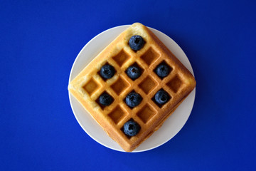Belgian waffles with berries on colorful background