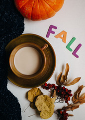 colorful letters Fall, Warm knitted scarf and cup of coffee with maple, Autumn leaves, pumpkin. Top view.