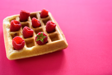 Belgian waffles with berries on colorful background
