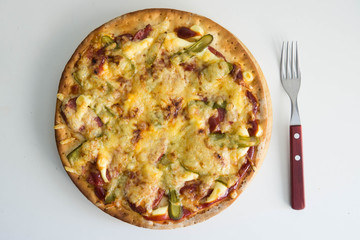 Homemade pizza with pickled cucumbers, sausages and cheese on wooden plate isolated, on white wooden background