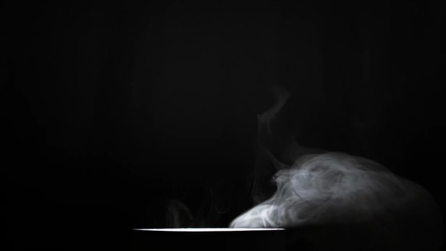 Smoke on dark background. Thick smoke curling over a luminous flashlight. Divination over the magical vessel. Beautiful smoke intro for logo.