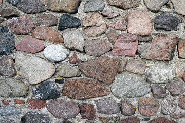 old fieldstone wall of field rocks. full frame background