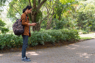 male travelers with backpack using gps map on tablet for sightseeing in the park. concept of...