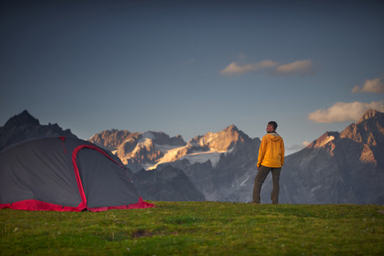 Hiker In A Camp And Looking At Mountains In A Sumer Day.