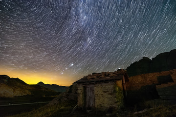 stars trails and isolated house in switzerland alps