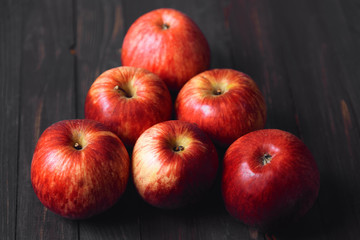 Red apples on a brown wooden background